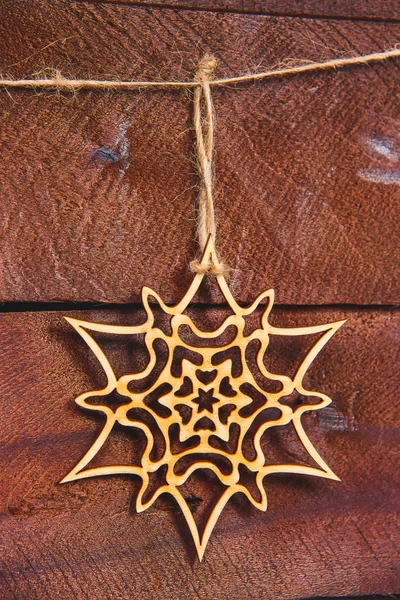 Christmas snowflakes on a wooden background. Eco-friendly toys for decorating the Christmas tree. Wood products for decoration. Christmas decorations made of plywood