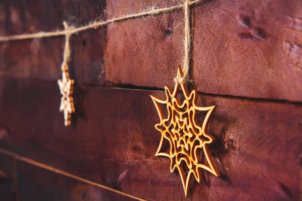 Christmas snowflakes on a wooden background. Eco-friendly toys for decorating the Christmas tree. Wood products for decoration. Christmas decorations made of plywood