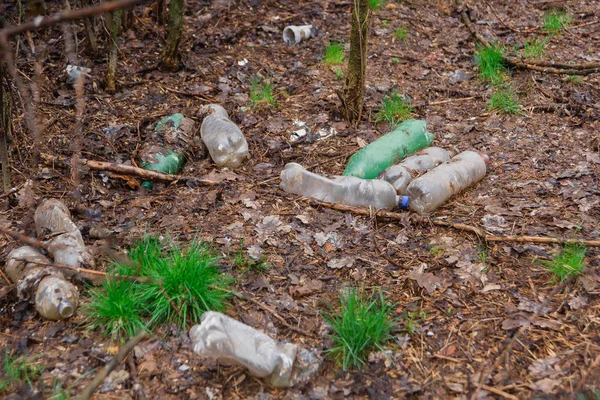 Old plastic bottles on the ground. Environmental pollution. Ecological catastrophy. Non-decomposable human waste.