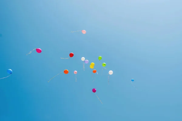 Multicolored balloons in the sky. Blue sky and balloons. Colored balloons released into the sky.