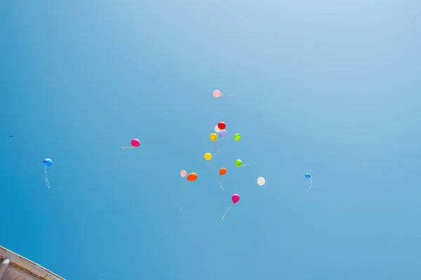 Multicolored balloons in the sky. Blue sky and balloons. Colored balloons released into the sky.