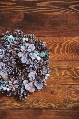 El yapımı Noel çelenk. Dekorasyon ahşap bir duvar. Koniler ahşap arka plan üzerinde yuvarlak çelenk. Çevre dostu oyuncak. Noel dekorasyonu. Tatil için ev yapımı şeyler