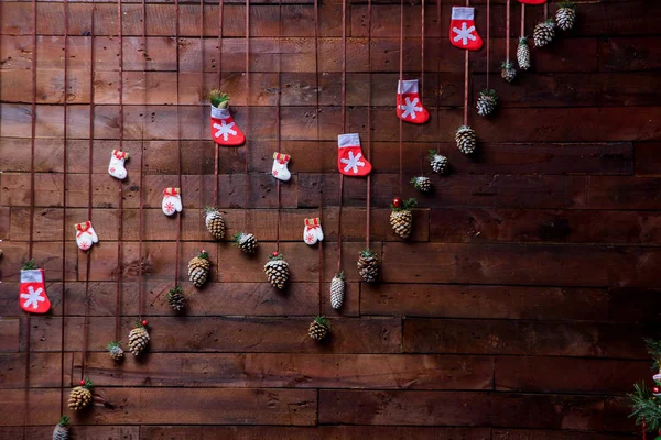 Christmas decorations on a wooden wall. Simple festive decoration at home. DIY xmas decoration. Spruce Cones for Christmas decoration.