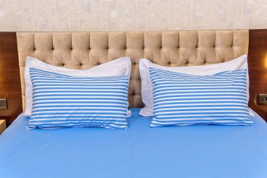 Cotton bedding. White-blue striped pillows. Fabric texture. Pillows and blankets are on the bed. A set of textiles for the bedroom. Beautiful and high quality linens. blankets and pillow on the bed. clipart
