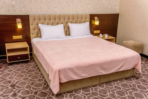 Bedroom interior with beautiful beds and linens. Single bed pink and blue. Double beds with white and color sheets. beige interior. soft poduishi blankets