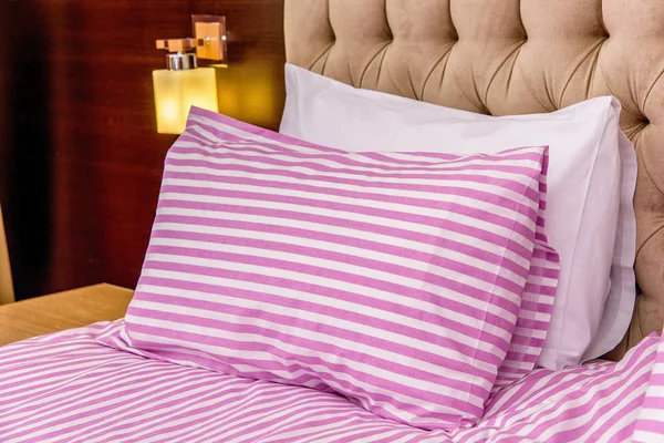 Bedroom interior with beautiful beds and linens. Single bed pink and blue. Double beds with white and color sheets. beige interior. soft poduishi blankets