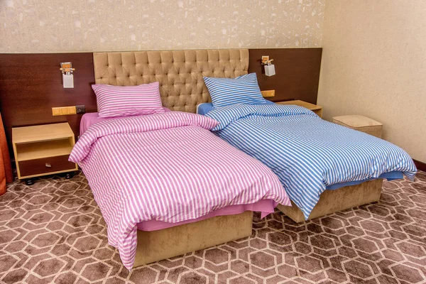 卧室内部配有漂亮的床和床单 单人床粉红色和蓝色 双人床配有白色和彩色床单 米色内饰 软软毛石毛毯 — 图库照片