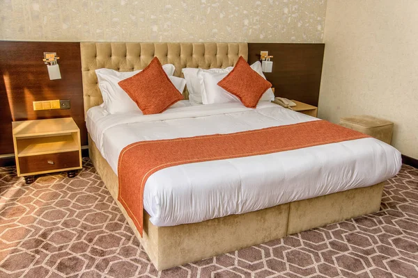 beautiful bedroom interior. Double bed with white and orange linens. beautiful and comfortable soft pillows. bed linen for home and hotel. beige bed.