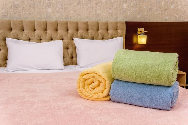 浴室用五颜六色的毛巾 柔软和温柔的纹理为酒店的毛巾 明亮的颜色蓬松的毛巾回家 毛巾和枕头躺在床上 在内部的毛巾 — 图库照片