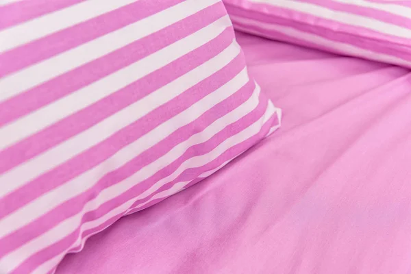 Cotton textile fabric with a pattern. Cotton with pink and white stripes. Pink textile background. Bed linen in white and pink cotton fabric colors. Production of textiles for the home. Fabric with a pattern.
