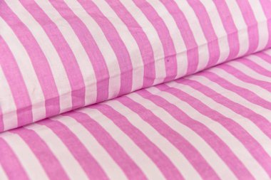 Pamuk tekstil kumaş desen ile. Pamuk pembe ve beyaz çizgili. Pembe Tekstil arka plan. Beyaz ve pembe pamuk kumaş renkleri yatak çarşafları. Ev tekstili imalatı. Bir desenli kumaş.