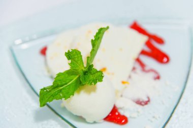 Dondurma Tatlı tabakta nane yaprakları ile süslenmiş. Dondurmalı tatlı şurubu. Hava pasta dondurma ile. Tüm aile için lezzetli tatlı.