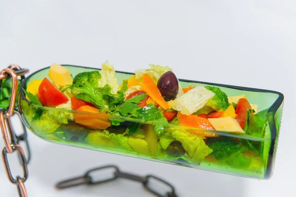 装饰花瓶配瓶形沙拉 带有软木塞和链子的瓶颈 蔬菜沙拉在沙拉碗里 绿色玻璃瓶和金属链 — 图库照片