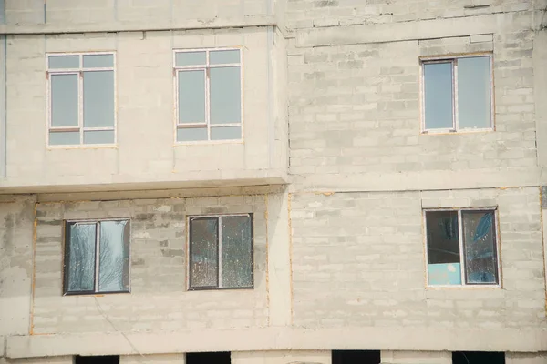 Construction of a multi-storey residential building. yellow crane on the background of the construction. special equipment at the construction site. unfinished monolithic house.