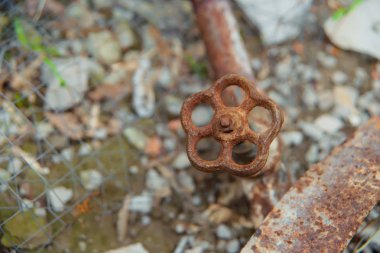 Paslı eski sıhhi tesisat havalandırma. paslı metal boru. Toprak zemin üzerine Ventel. Gri taş ve pas renkli boru. Vintage sıhhi bağlantı parçaları.