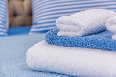 Pamuk havlu ve yatak çarşafları. Küme gök mavisi yatak çarşafları. Mavi çizgili desenli yastıklar. Havlu otel kompleksi için farklı boyutlarda. Doğal pamuk tekstil iç.