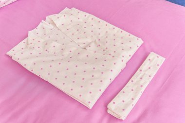 Rengi pamuklu bornozlar otel için. Bir daire desenli pembe ve beyaz bornoz. Hafif yaz sabahlıklar bir kemer ile. Bir askı üzerinde asılı bornoz. İç ev tekstili.