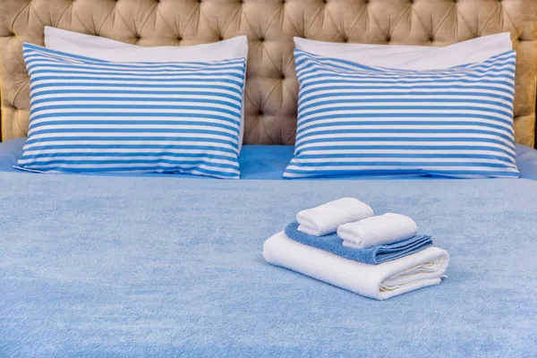 床单和棉质毛巾 设置天蓝色床单 蓝色条纹图案的枕头 不同大小的毛巾为酒店综合体 室内天然棉纺织品 — 图库照片