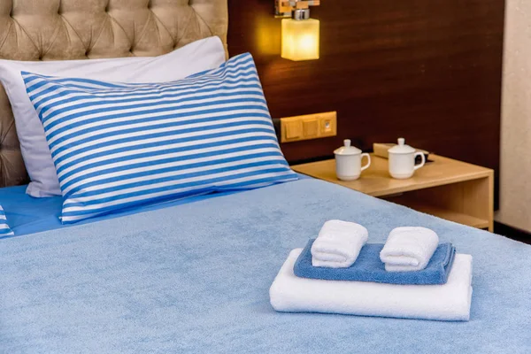 床单和棉质毛巾 设置天蓝色床单 蓝色条纹图案的枕头 不同大小的毛巾为酒店综合体 室内天然棉纺织品 — 图库照片