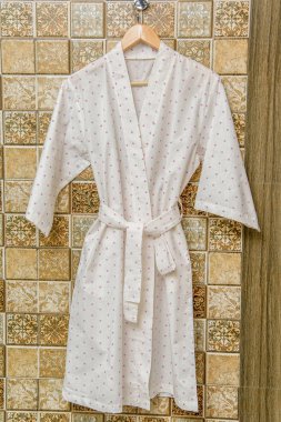 Rengi pamuklu bornozlar otel için. Bir daire desenli pembe ve beyaz bornoz. Hafif yaz sabahlıklar bir kemer ile. Bir askı üzerinde asılı bornoz. İç ev tekstili.
