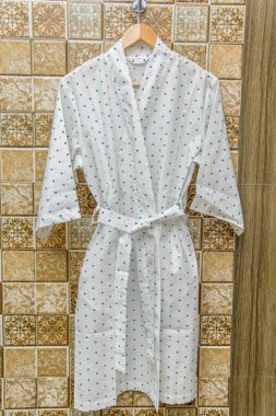 Rengi pamuklu bornozlar otel için. Bir daire desenli pembe ve beyaz bornoz. Hafif yaz sabahlıklar bir kemer ile. Bir askı üzerinde asılı bornoz. İç ev tekstili.