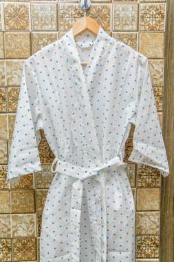 Rengi pamuklu bornozlar otel için. Bir daire desenli pembe ve beyaz bornoz. Hafif yaz sabahlıklar bir kemer ile. Bir askı üzerinde asılı bornoz. İç ev tekstili.