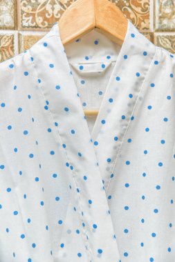 Rengi pamuklu bornozlar otel için. Bir daire desenli pembe ve beyaz bornoz. Hafif yaz sabahlıklar bir kemer ile. Bir askı üzerinde asılı bornoz. İç ev tekstili.