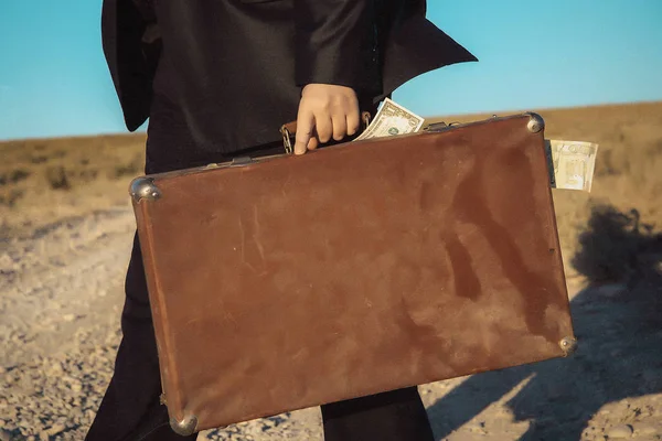People with old suitcases. Old vintage suitcase. A girl with a brown suitcase. Leather case with handles and metal rivets. Male figure with a suitcase filled with money.