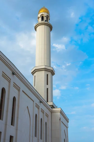 White mosque. Golden dome and crescent. Minaret. The central entrance door to the Muslim mosque. Mosque on a sunset background. Night landscape minaret. Beautiful architecture.