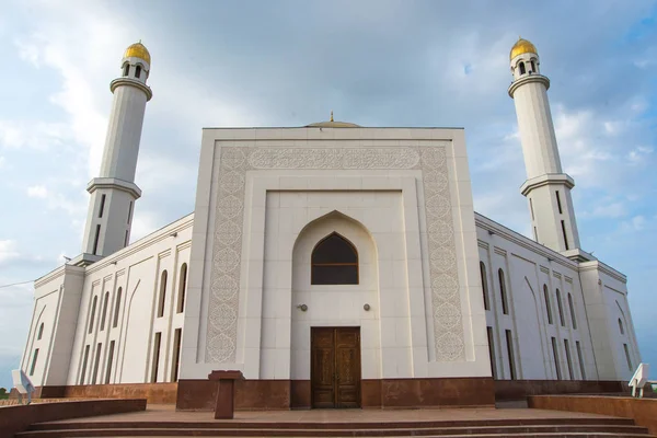 White mosque. Golden dome and crescent. Minaret. The central entrance door to the Muslim mosque. Mosque on a sunset background. Night landscape minaret. Beautiful architecture.