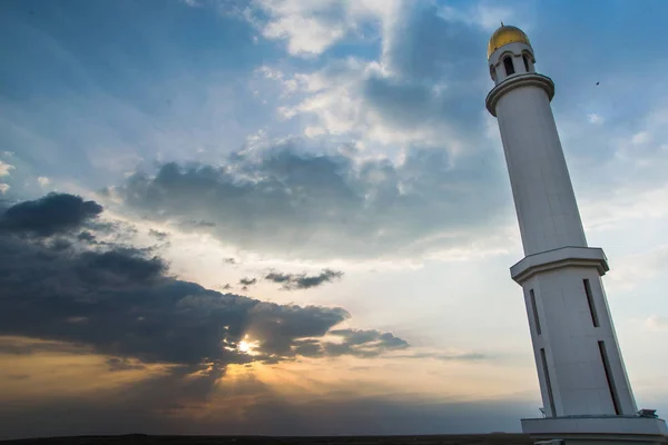 White mosque. Golden dome and crescent. Minaret. The central entrance door to the Muslim mosque. Mosque on a sunset background. Night landscape minaret. Beautiful architecture.