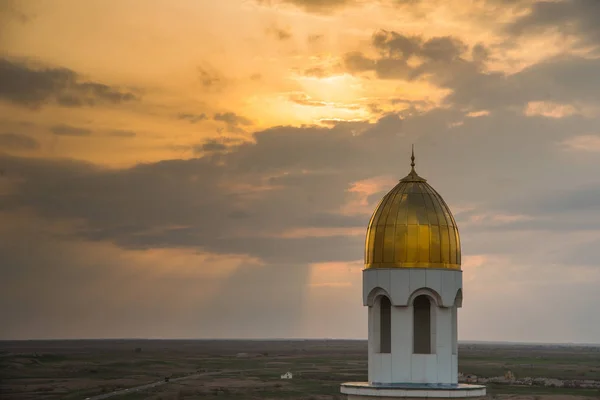 White mosque. Golden dome and crescent. Minaret. The central entrance door to the Muslim mosque. Mosque on a sunset background. Night landscape minaret. Beautiful architecture.