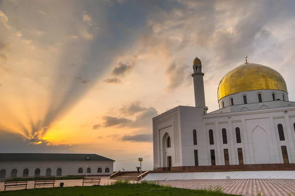 White mosque. Golden dome and crescent. Minaret. The central entrance door to the Muslim mosque. Mosque on a sunset background. Night landscape minaret. Beautiful architecture.