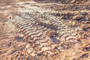 Sırt--dan yere izlemek. Lastikler ıslak kil künye. Kahverengi kir izleri üzerinden araba tekerlekleri olan. Farklı makineler şehrin yapımında da izleri.