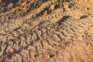 Sırt--dan yere izlemek. Lastikler ıslak kil künye. Kahverengi kir izleri üzerinden araba tekerlekleri olan. Farklı makineler şehrin yapımında da izleri.