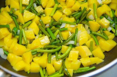 Patates kızartması yemek. Doğranmış patatesler kızarmış. Soğan ve yeşil sarımsak. Köpük bitkisel yağ kaynar. Bir vejetaryen yemek yapma. Lezzetli ve sağlıklı gıda.