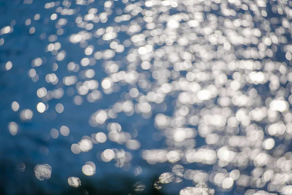 水的涟漪 水面上的微光 银灰色和蓝色的水与太阳的光线反射 带白色圆圈的蓝色摄影英语 水面上的光芒的反映 水面和海浪 — 图库照片