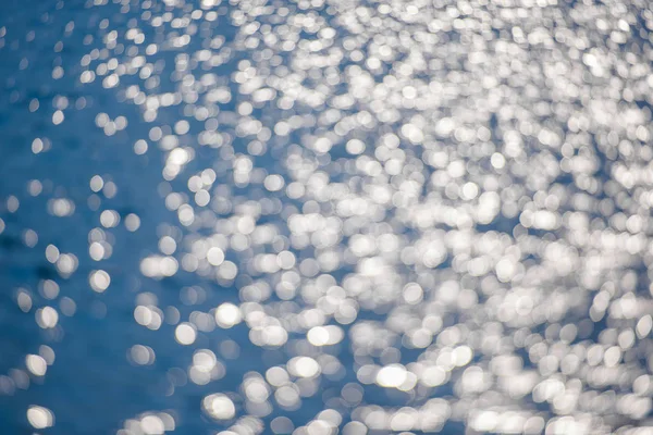 水的涟漪 水面上的微光 银灰色和蓝色的水与太阳的光线反射 带白色圆圈的蓝色摄影英语 水面上的光芒的反映 水面和海浪 — 图库照片