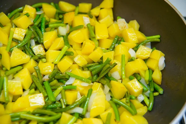 煮炸土豆 土豆丁是油炸的 洋葱和青大蒜 煮沸发泡植物油 做素食餐 美味健康的食物 — 图库照片