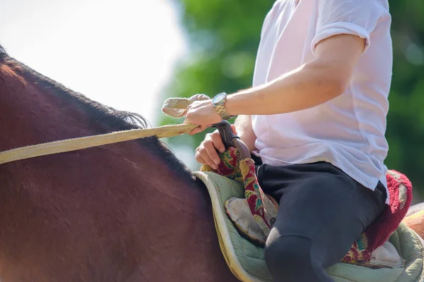 馬のサドルでライダー レース用機材を属性します 特別なブーツは 乗馬スポーツのための手袋 女の子と男の子のレース前に馬に乗って 美しいサドル 馬をサドルします ヘルメット — ストック写真