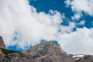 Karla kaplı dağlar. Mavi gökyüzü ile kalın bulutlar. Rocky Dağları doruklarına. Kazakistan dağ manzarası. Tepe Sairam-Su. Dağlarda hiking. Ugamsky dağ.