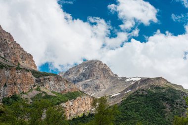 Karla kaplı dağlar. Mavi gökyüzü ile kalın bulutlar. Rocky Dağları doruklarına. Kazakistan dağ manzarası. Tepe Sairam-Su. Dağlarda hiking. Ugamsky dağ.