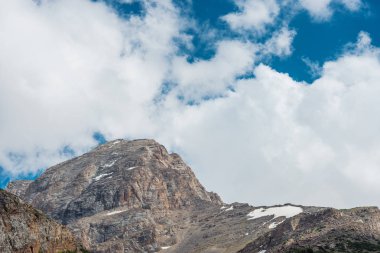 Karla kaplı dağlar. Mavi gökyüzü ile kalın bulutlar. Rocky Dağları doruklarına. Kazakistan dağ manzarası. Tepe Sairam-Su. Dağlarda hiking. Ugamsky dağ.