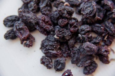 Beyaz bir arka plan üzerinde eksik kuru üzüm. Şımarık Kuruyemiş hafif bir arka plan üzerinde. Beyaz solucanlar. Karanlık kuru üzüm üzerinde böcek larvaları. Kurutulmuş meyve solucanlar. Parazitler şımarık ürünlerde.