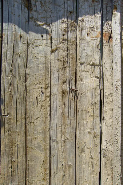 Old wooden fence. Woody structure. A fence made of wood. Cracked dry wood. Burnt wood surface.