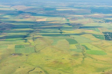 Sürülmüş alanlar. Hasat. Yeşil engebeli yüzey. Engebeli arazi. Doğada bitki örtüsü. Bird's-Eye. Kırsal faaliyetleri.