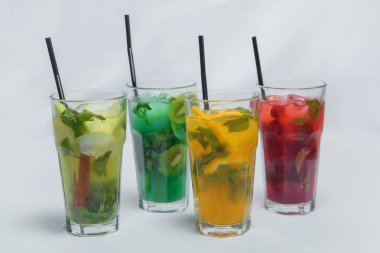 Apple, tropikal, berry, meyve limonata. Serinletici içecekler buz ile. Cam bardak soğuk kokteyller. Parlak renkli içecekler. Beyaz bir arka plan üzerinde bardaklarda limonata.