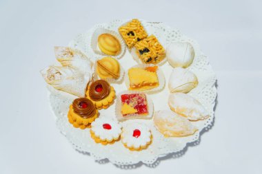 Çok renkli mini kek. Kek adı altında: Petit dört. Tatlı hamur işleri. Tatlılar: Petit Fours. Çerezler shortcrust pasta beyaz bir arka plan üzerinde yapılmıştır. Tüpler şeklinde pasta. Tatlı.