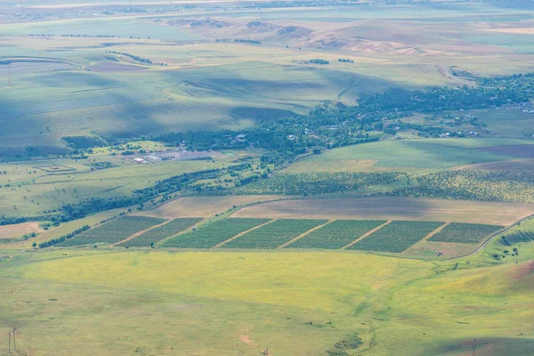 Sürülmüş alanlar. Hasat. Yeşil engebeli yüzey. Engebeli arazi. Doğada bitki örtüsü. Bird's-Eye. Kırsal faaliyetleri.