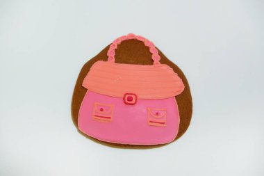 Gösterişli bir kadın çanta şeklinde. Şekerlemeler. Tatlı hamur işleri. Tanımlama bilgilerini buzlanma ile kaplı. Beyaz bir arka plan üzerinde zencefilli kurabiye pişirme. Gingerbread.